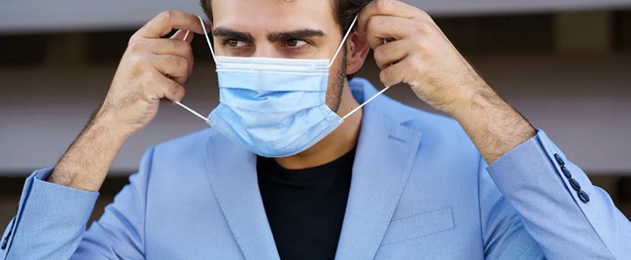 businessman-putting-on-a-surgical-mask-to-protect-94kuujz-wsZ8xN.webp